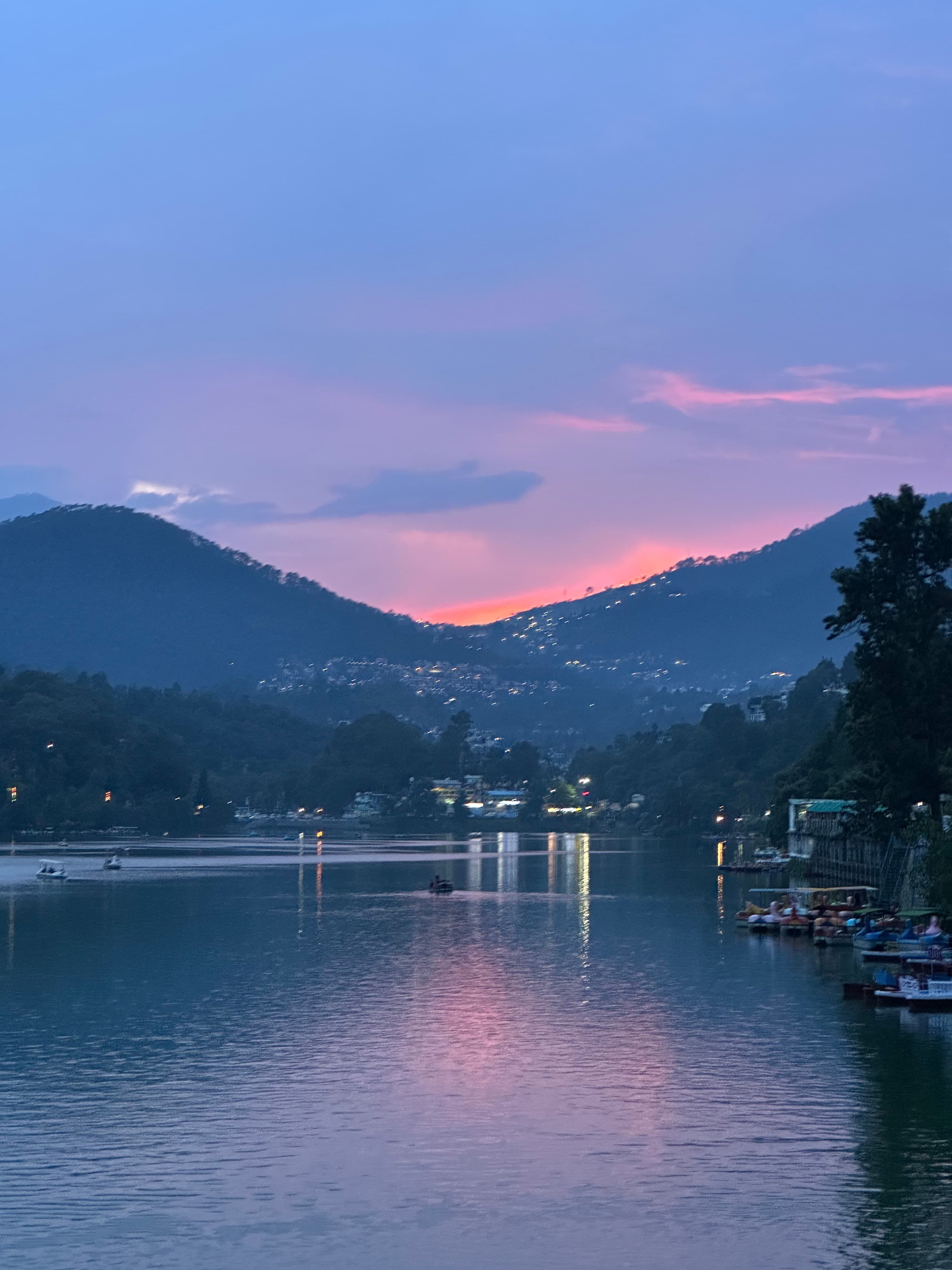 Pink evening light reflected across Naini Lake