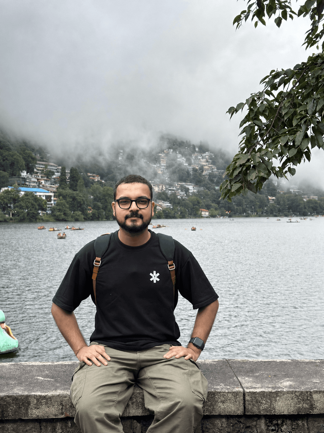 A portrait of me sitting beside Naini Lake on a foggy day