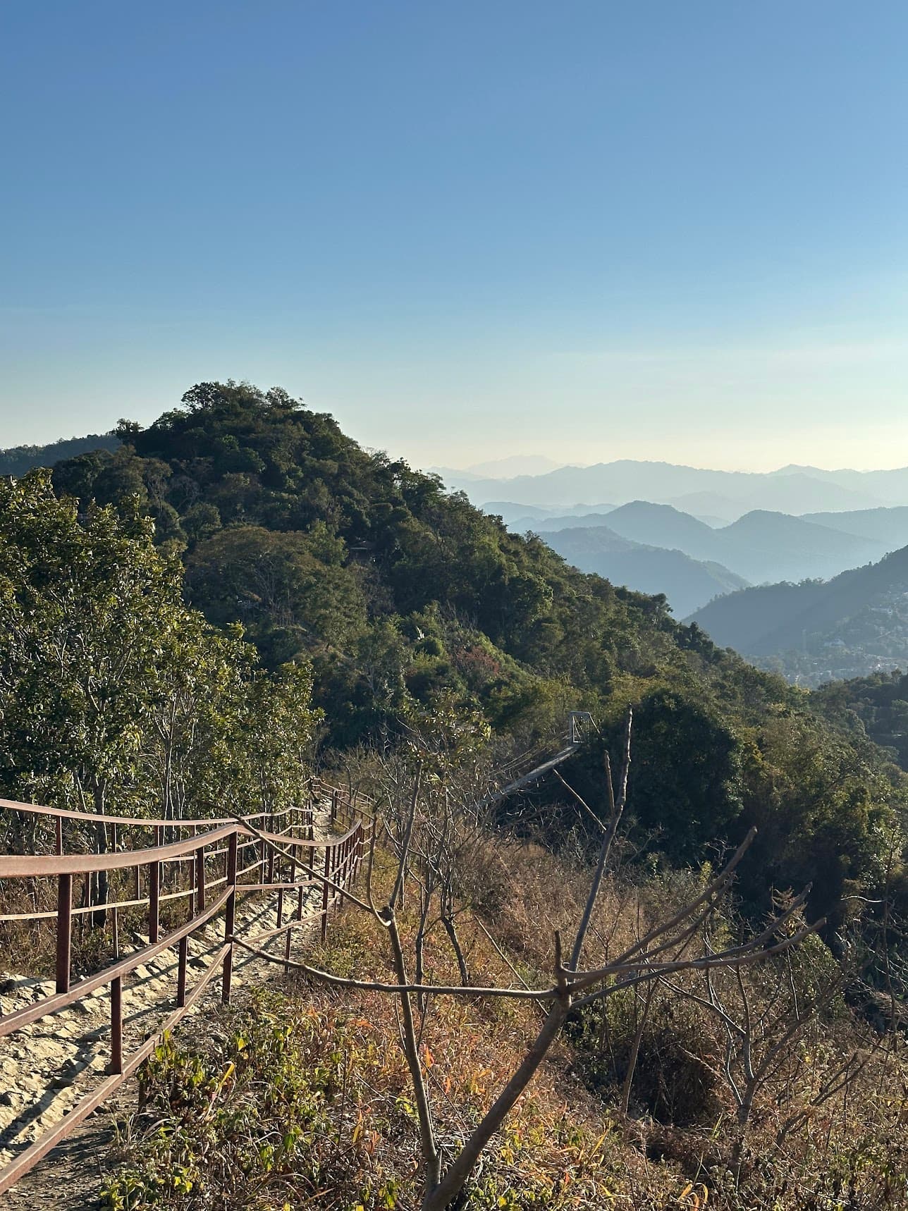 Mountain road and railing above Aizawl with layered hills in the distance