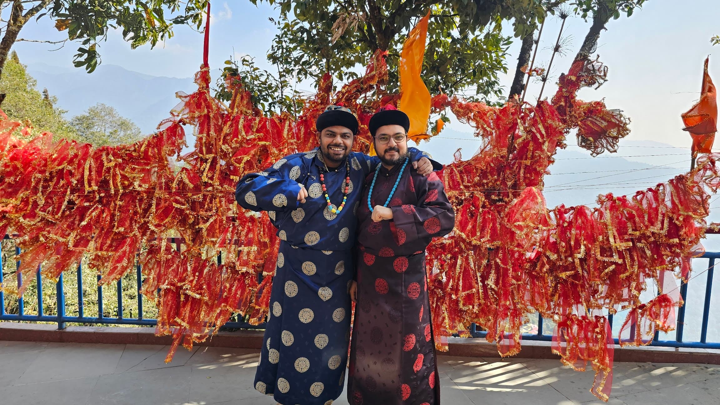 Travelers standing in front of colorful prayer flags in Gangtok