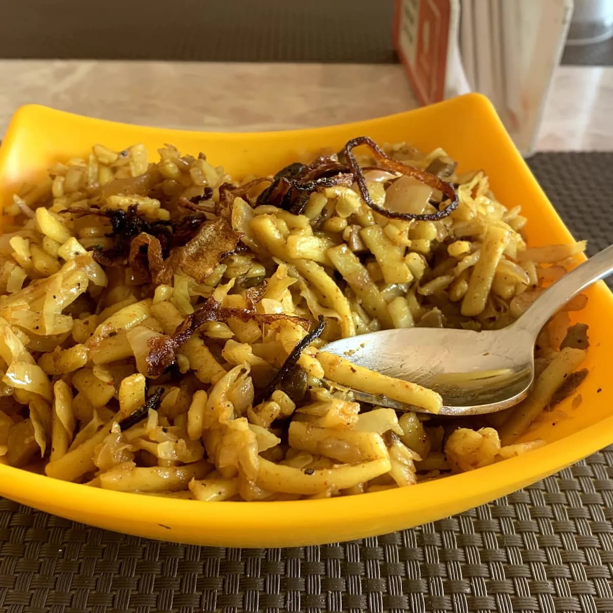 A plate of Burmese atho topped with fried onions